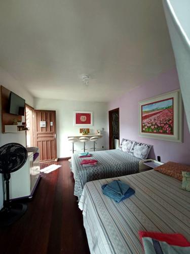 a hotel room with two beds and a table at Residencial Rodrigues Florianópolis in Florianópolis