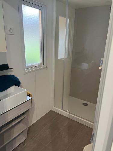 a bathroom with a shower and a toilet and a window at camping bonneval in Jaujac