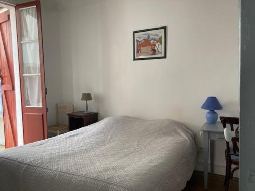 una camera da letto con un letto, un tavolo e una finestra di Etchebarne a Saint-Jean-de-Luz