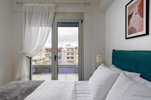 a bedroom with a bed and a sliding glass door at Anatoli Urban Apartment with private parking in Xanthi