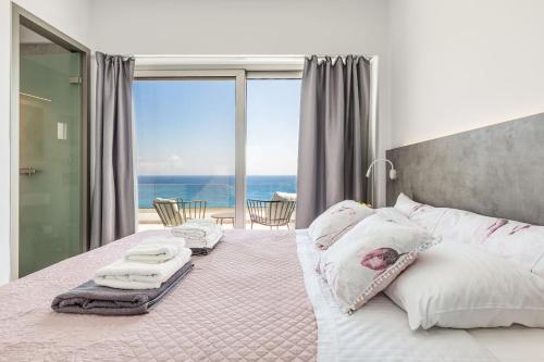 a bedroom with a bed with a view of the ocean at Villa Anatoli in Achlia