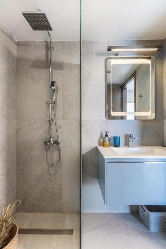 a bathroom with a shower with a sink and a mirror at Villa Anatoli in Achlia