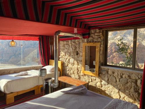 a bedroom with two beds and a stone wall at Dana Trail Cottages in Dana