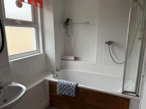 a bathroom with a tub and a shower and a sink at 17 Main Street in St Bees