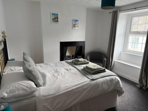 a bedroom with a white bed with two pillows on it at 17 Main Street in St Bees