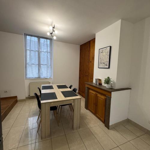 a kitchen with a table and chairs in a room at Le Nid Bressan in Bourg-en-Bresse