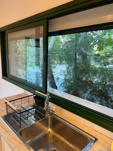a kitchen sink with a large window above it at Kalidoniahouses in Perapedhi