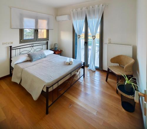 a bedroom with a bed and a table and a chair at V Mira Luxury Villa in Tragaki