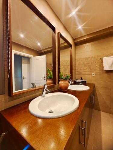 a bathroom with two sinks and a large mirror at V Mira Luxury Villa in Tragaki