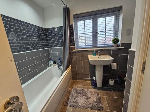a bathroom with a sink and a bath tub and a sink at Modern spacious Home in Rhyl in Rhyl