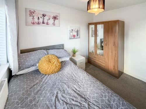 a bedroom with a gray bed with a wooden cabinet at Modern spacious Home in Rhyl in Rhyl