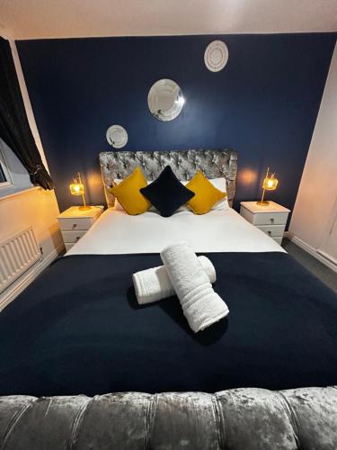 a bedroom with a large bed with yellow and black pillows at Park View House - Spacious 3 Bed Home in Burton in Burton upon Trent