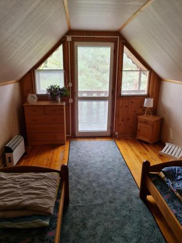 a bedroom with two beds and a room with windows at Domek nad jeziorem Anastazewo in Anastazewo