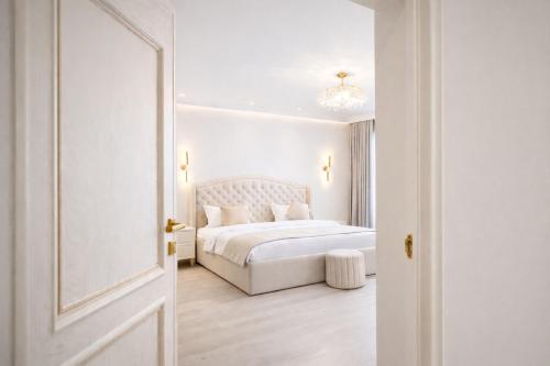 a white bedroom with a white bed and a door at Yerevan In Boutique Hotel in Yerevan