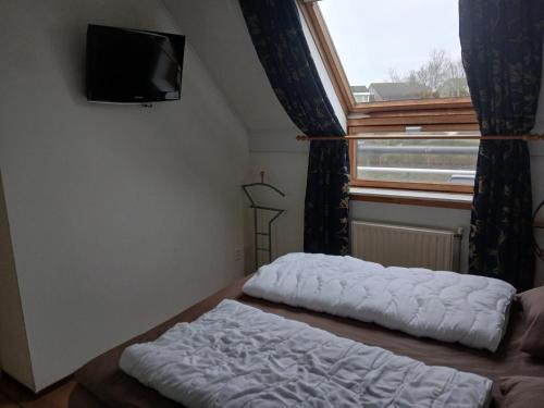 una stanza con un letto, una finestra e una televisione di Centrum 26 a Brouwershaven