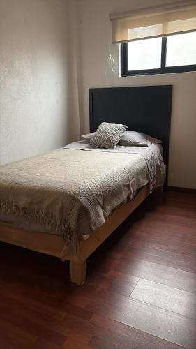 a bedroom with a bed in a room with a window at La Casa de Ikal Zacatlán in Zacatlán