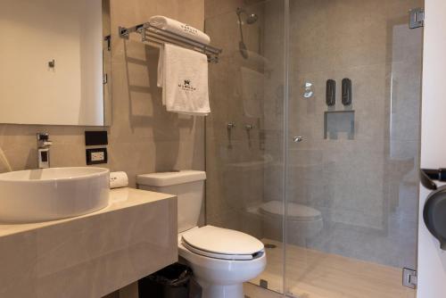 ein Badezimmer mit Dusche, Toilette und Waschbecken in der Unterkunft MARUVA Hotel Ejecutivo in Tecomán