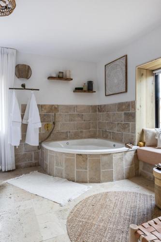a bathroom with a bath tub in a room at אי שם בגולן in Keshet