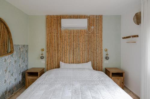 a bedroom with a bed with two tables and a window at אי שם בגולן in Keshet