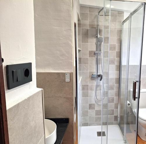 a bathroom with a glass shower with a toilet at Casa Trilles in Azuébar