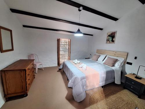 a bedroom with a large bed and a wooden table at Casa Trilles in Azuébar
