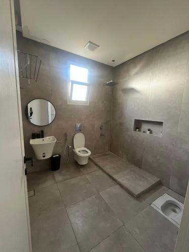 a bathroom with a toilet and a sink at فلو بارك in Unayzah