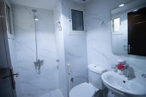 a bathroom with a shower and a toilet and a sink at فندق اسكان وافر in An Naqāʼ