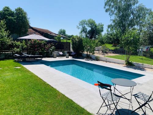 a swimming pool with chairs and a table in a yard at Pause Pedal Pyrénées in Capvern
