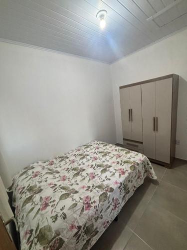 a bedroom with a bed and a cabinet at Casa in Rosário do Sul