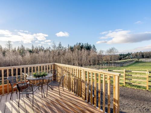a deck with a table and chairs and a fence at The Paddocks - Uk7112 in Alloa