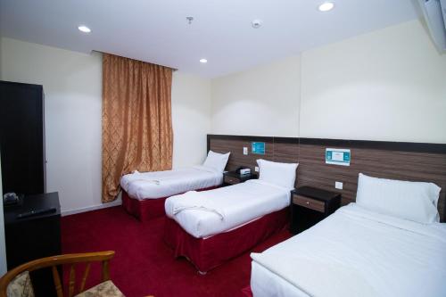 a hotel room with two beds and a window at فندق اسكان وافر in An Naqāʼ