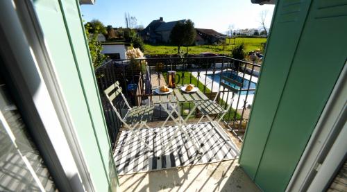 an open door to a balcony with chairs and a pool at Pause Pedal Pyrénées in Capvern