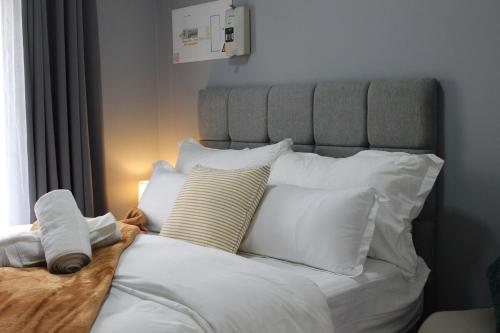 a bedroom with a white bed with white pillows at Stonewall Luxury Apartment in Northriding
