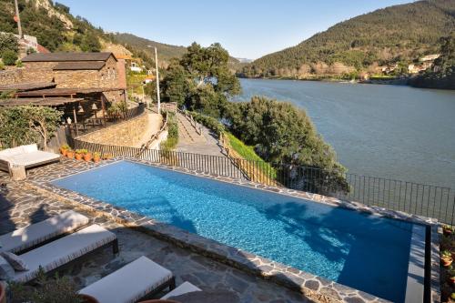 a swimming pool with a view of a river at DOURWIN Exclusive Suites & Restaurant - Adults Only in Sebolido