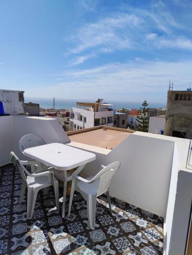 a balcony with a table and chairs on a roof at Tamraght samba 3 in Tamraght Ou Fella