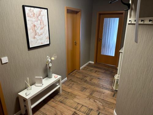 a hallway with a white table and a painting on the wall at Am Oberpark in Bad Muskau