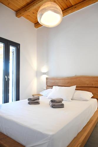 a bedroom with a white bed with towels on it at Alkyoni Celeste Kythnos in Kithnos