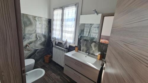 a bathroom with a sink and a toilet and a mirror at B&B Le Tre Vette in Scoppito