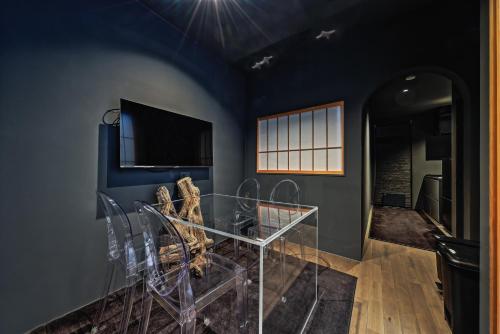 a living room with a glass table and a tv at NINE plus River with Private Sauna Stay in Kanazawa