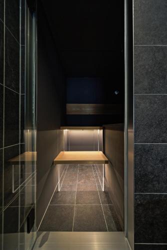 a walk in shower with a bench in a room at NINE plus River with Private Sauna Stay in Kanazawa