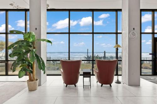 a room with two chairs and a view of the ocean at Beach Studio with Partial Water Views Sundeck Pool in Daytona Beach