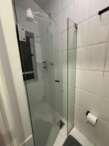 a bathroom with a shower with a glass door at Apê do Viajante in Vila Velha