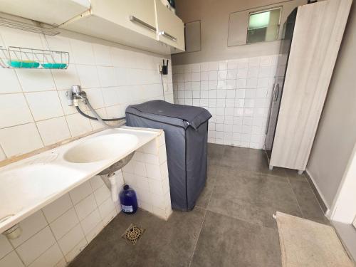 a bathroom with a blue suitcase next to a sink at Casa dos Carvalhos in Piranhas