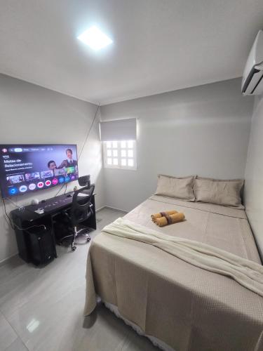 a bedroom with a bed and a desk and a television at Casa dos Carvalhos in Piranhas