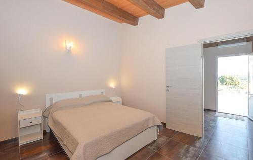 a white bedroom with a bed and a sliding door at A Valata di Donnafugata in Ragusa