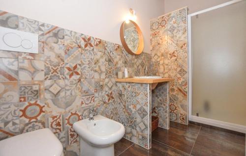 a bathroom with a toilet and a sink and a mirror at A Valata di Donnafugata in Ragusa