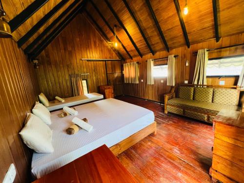 a bedroom with a large bed and a couch at Sigiriya Coconut Shade Resort in Sigiriya