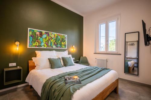 a bedroom with a large bed with a painting on the wall at La Corte Rooms Pisa in Pisa