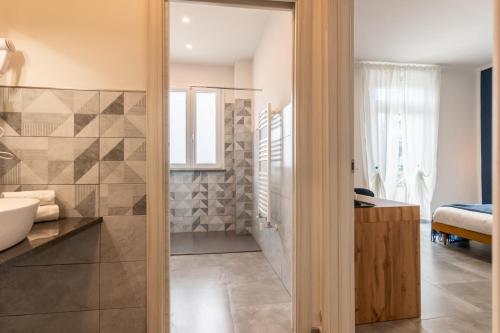 a bathroom with a tub and a sink at La Corte Rooms Pisa in Pisa