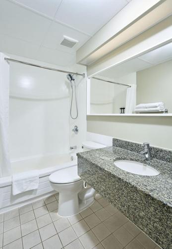 a bathroom with a toilet and a sink at Canad Inns Destination Centre Windsor Park in Winnipeg